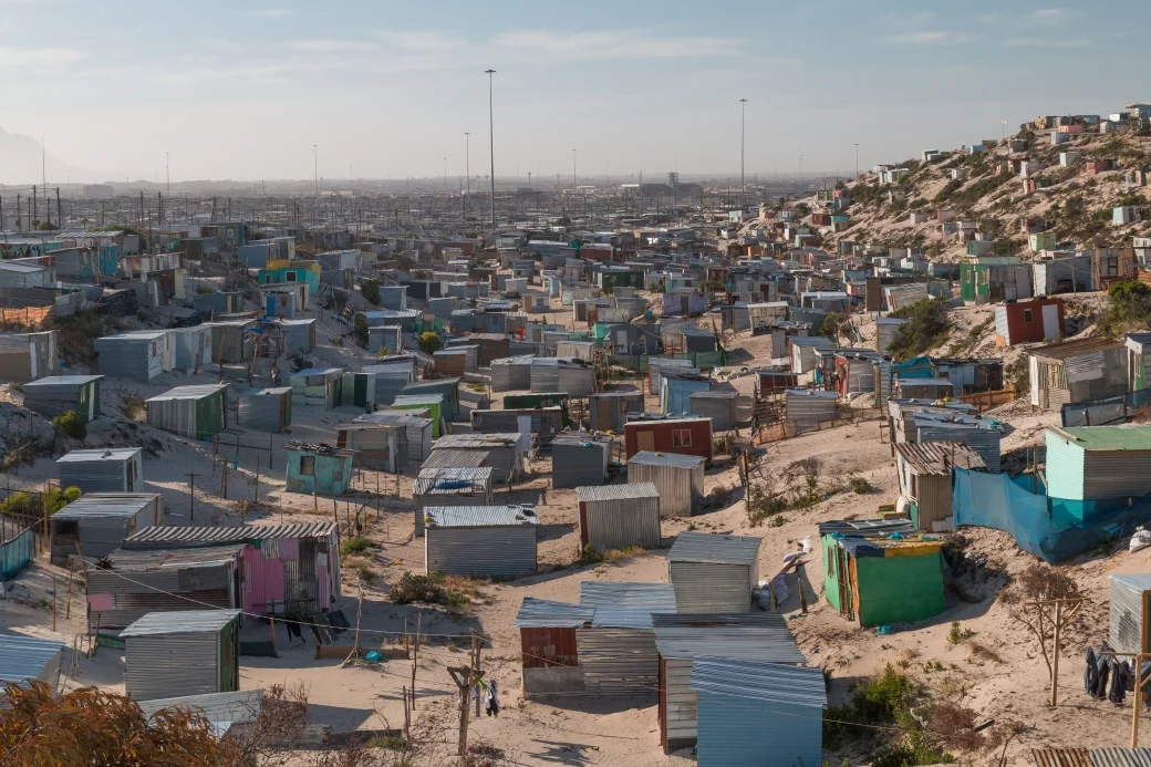 A densely populated township in South Africa, with rows of small, colorful houses