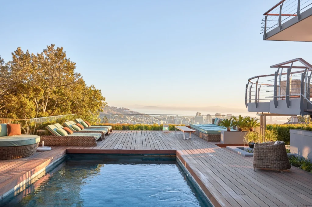 Pool and deck area at Atzaró Cape Town with large daybeds and panoramic views over Cape Town.