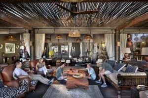 A family relaxing and playing board games in the luxury lounge of Atzaró Okavango Delta Camp, the next stop after Atzaró Cape Town.