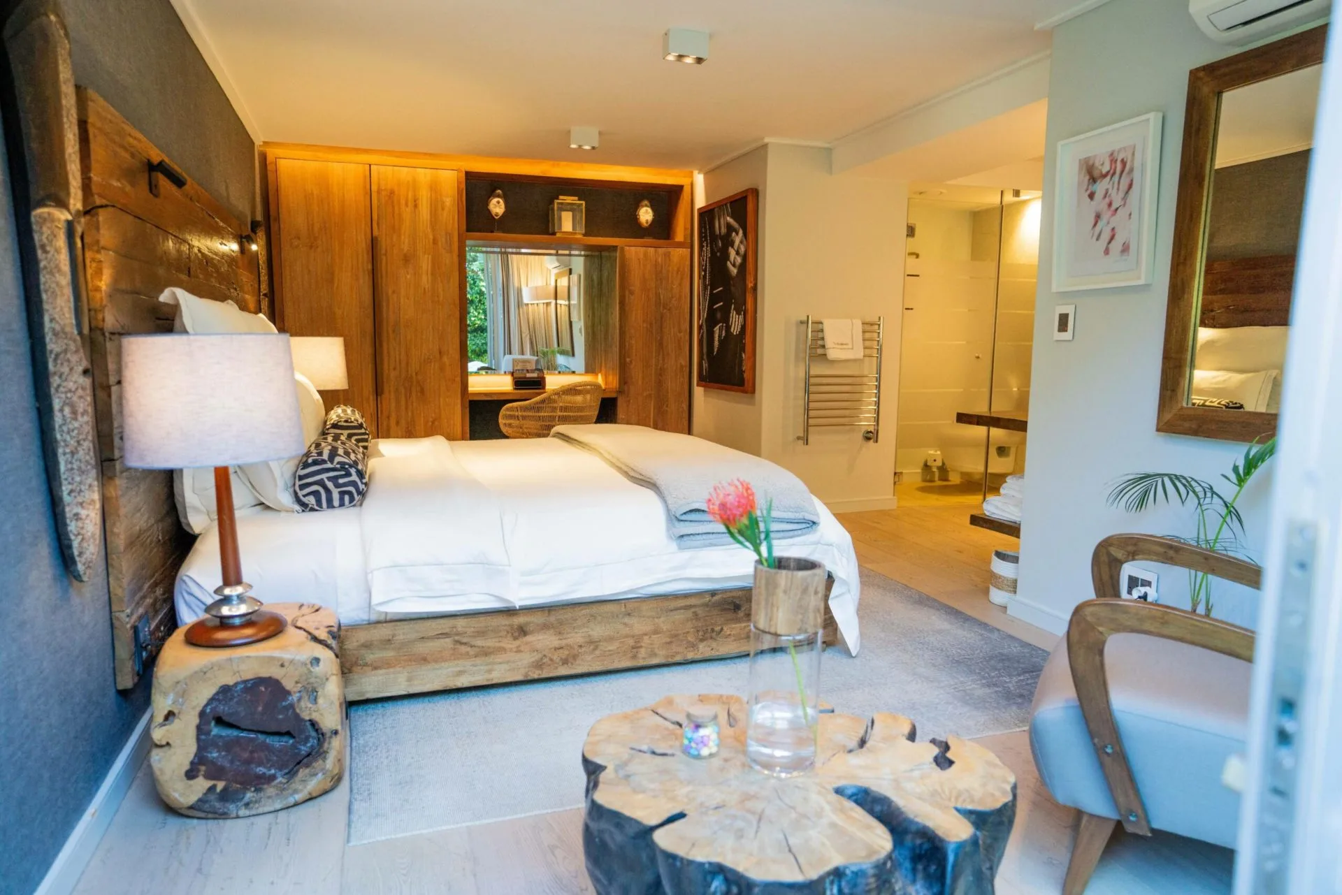 Luxury interior of the Mopane bedroom in the Family Suite at Atzaró Cape Town, featuring warm wood accents, a king-size bed, and African-inspired decor.