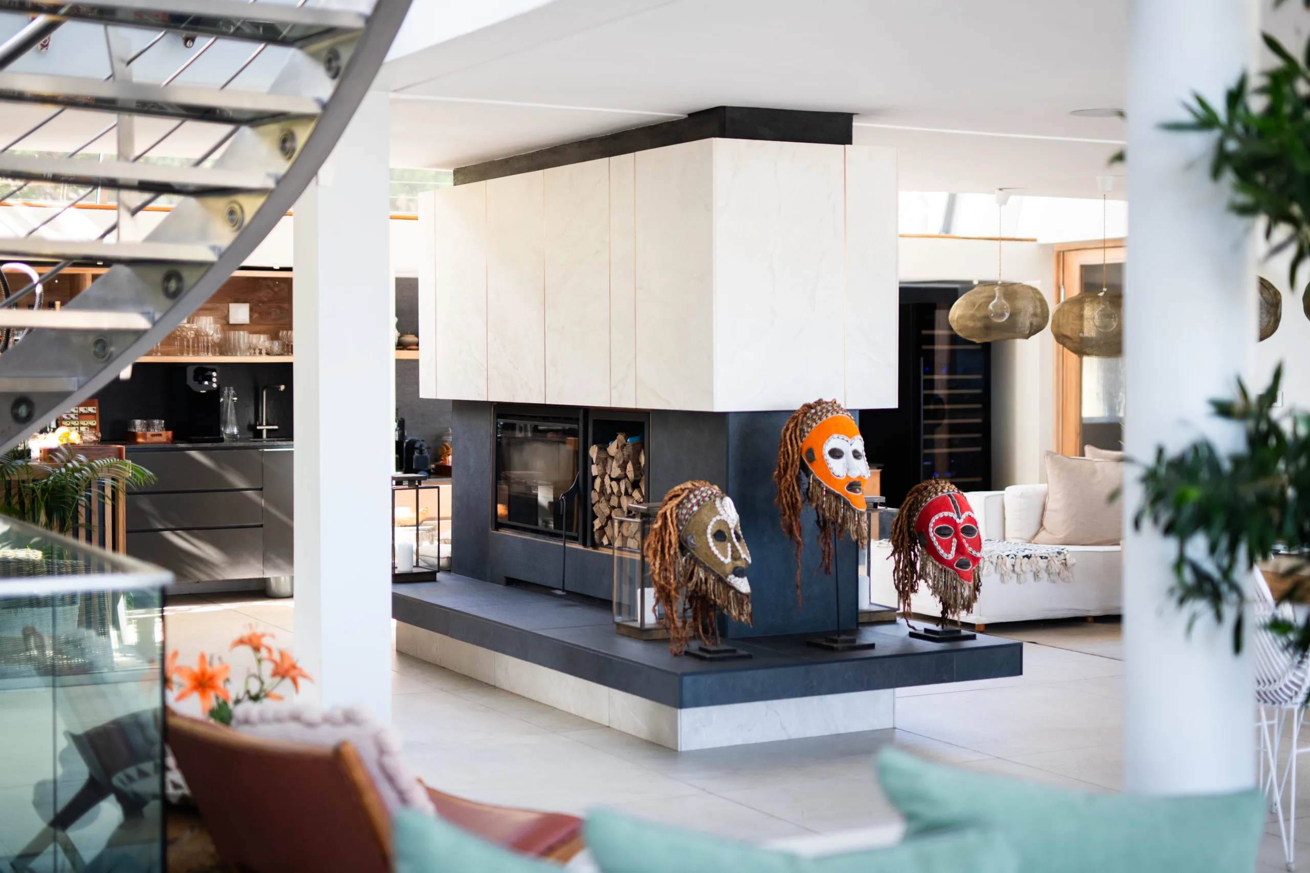 Hotel luxury main area with an elegant fireplace, African mask decoration, and sofas.