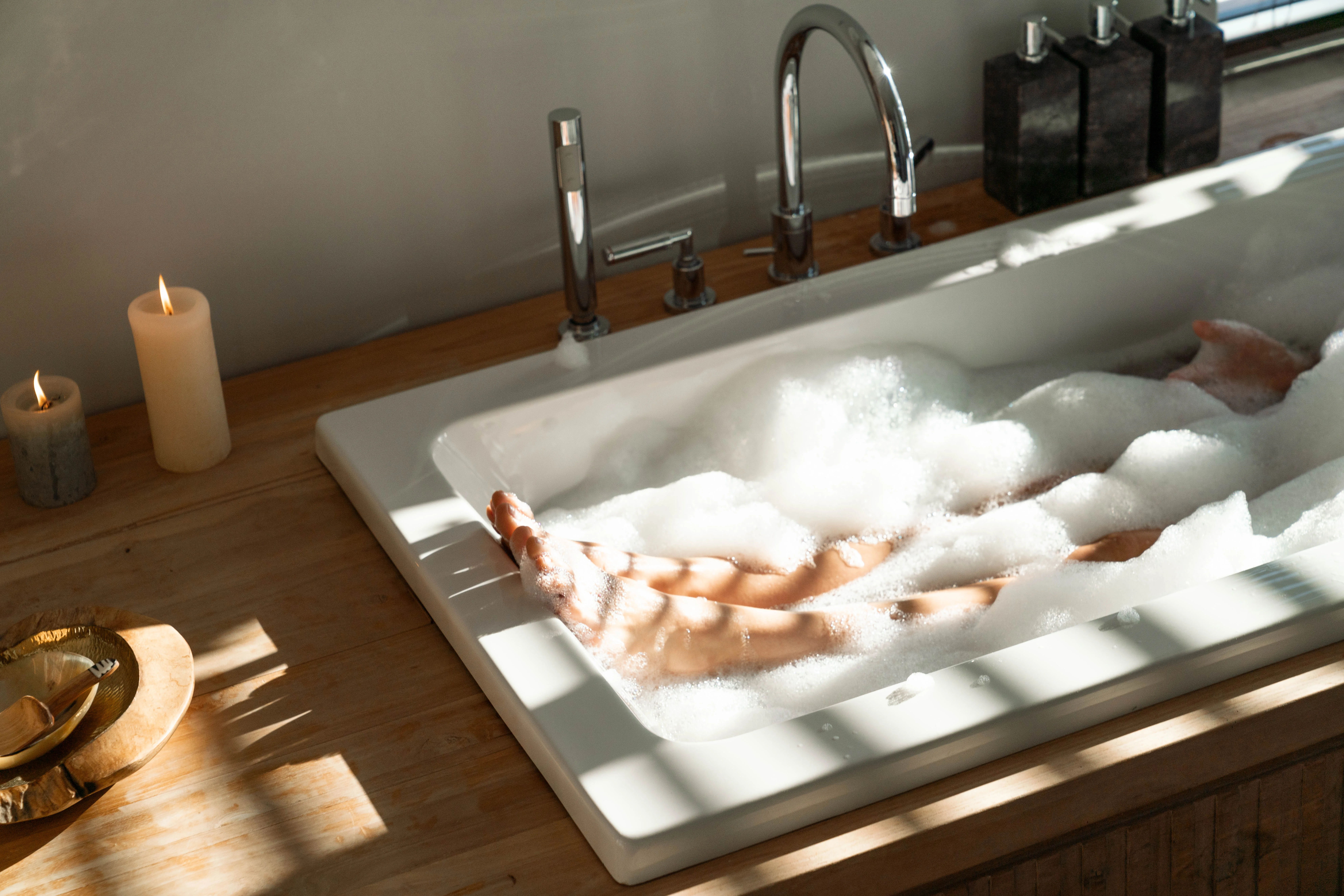 Woman's feet in the bath of the Madiba Suite in Atzaró Cape Town Luxury Hotel.