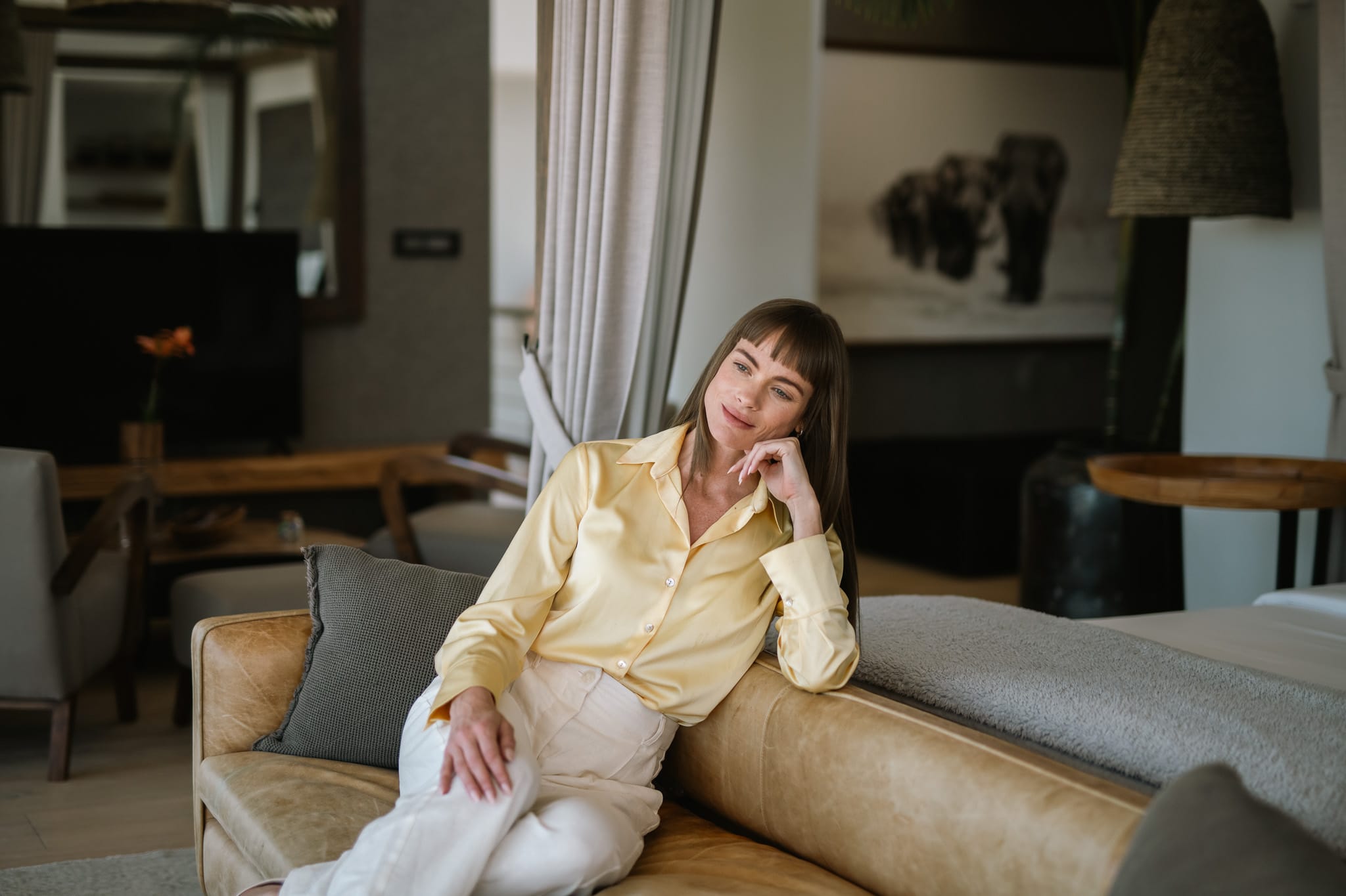 Woman relaxing on the sofa in the Lion's Head Suite of Atzaró Cape Town Luxury Hotel.