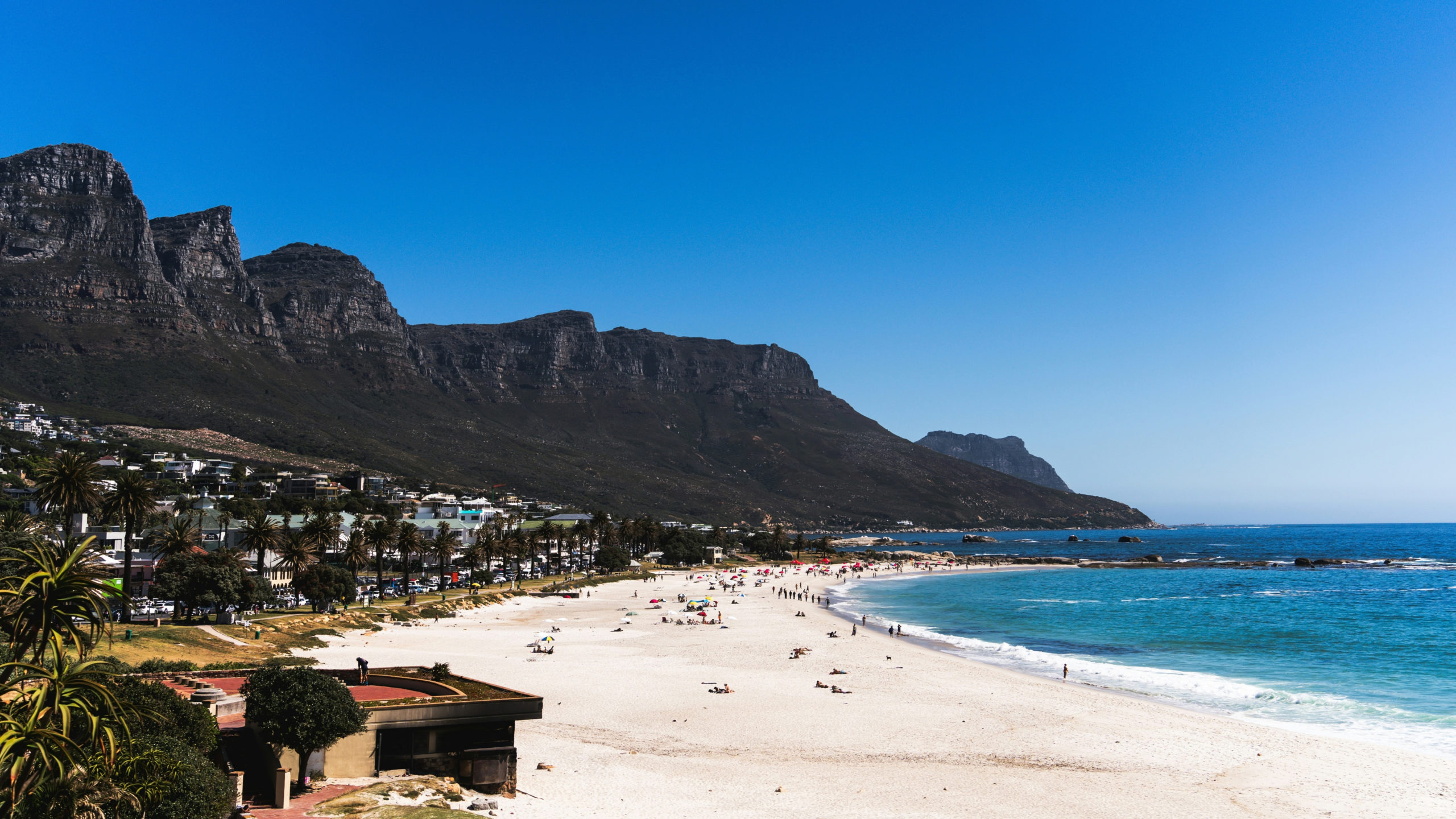 Camps Bay Beach in Cape Town with white sand, Victoria Road and the Twelve Apostles mountains behind