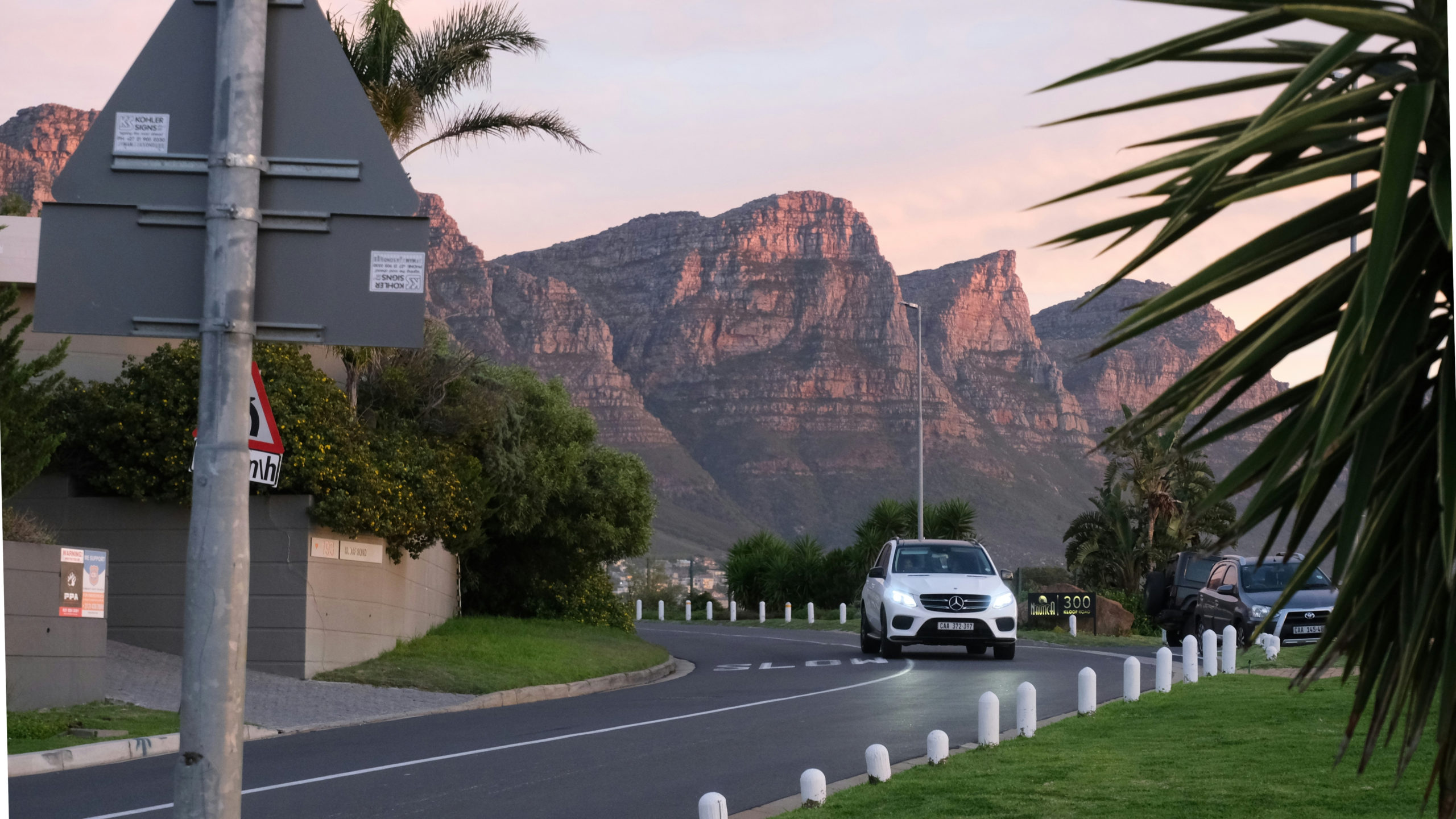 Private chauffeur driving along a scenic road in Cape Town, a safe way for tourists to get around